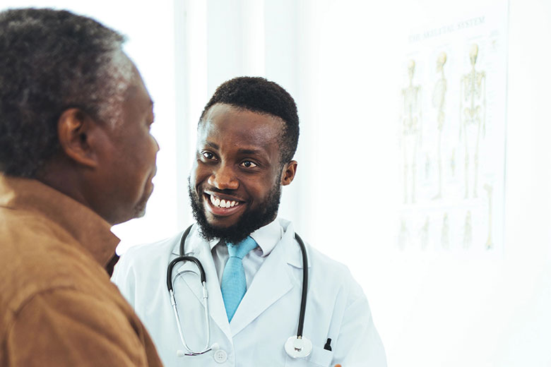 Male doctor speaking with elderly male patient